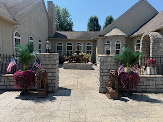 Grand stamped concrete entrance with stone pillars